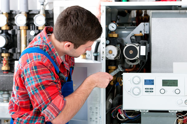 HVAC technician inspecting and repairing boiler controls in Broomfield