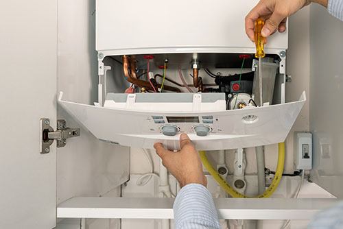 HVAC technician repairing an indoor boiler in Broomfield
