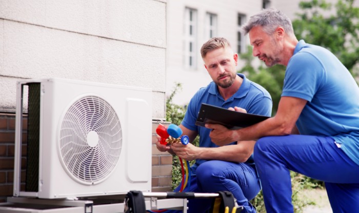 HVAC technicians installing an outdoor air conditioning unit in Broomfield
