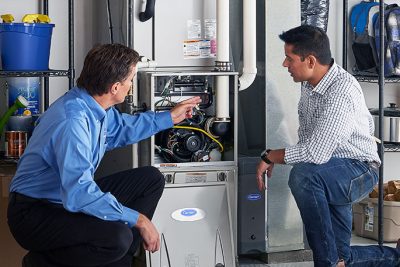 65df8c11f3e4c468cbd351a5_furnace repair vs replacement – Copy HVAC technician explaining furnace repair and maintenance to a homeowner in Broomfield, CO
