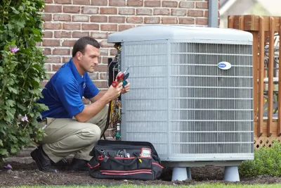 design-air-heating-and-air-conditioning-decatur-il-05 – Copy HVAC technician inspecting an outdoor air conditioning unit in Broomfield, CO