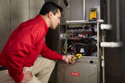 furnace repair Heating and air conditioning technician servicing an indoor furnace in Broomfield, CO